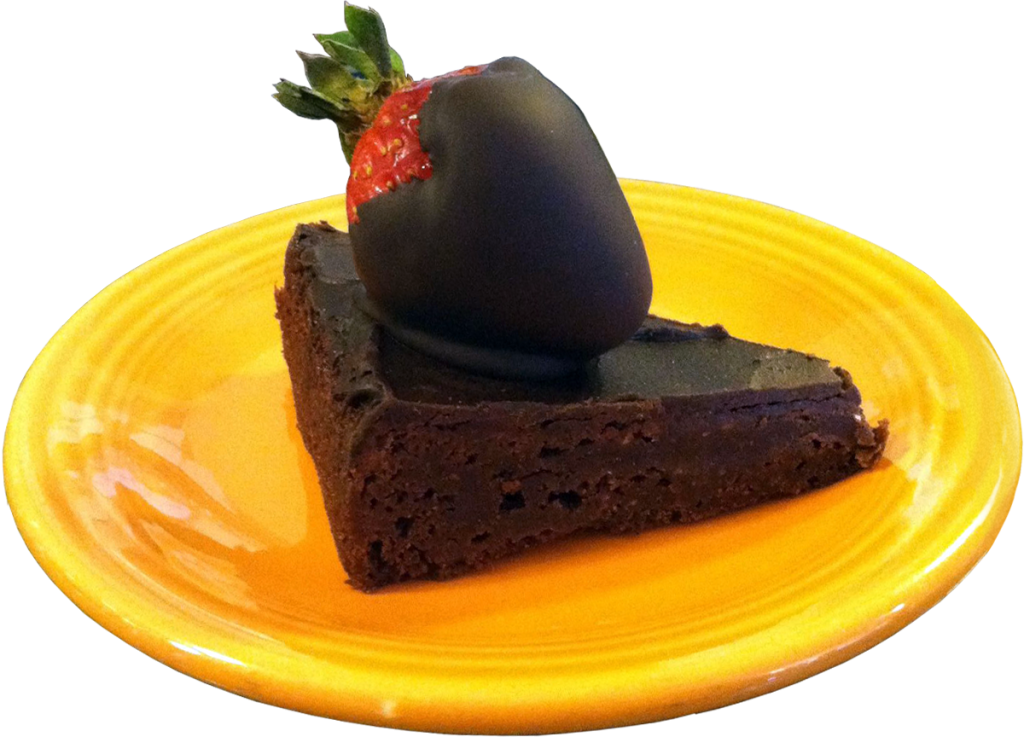 chocolate cake topped with chocolate covered strawberry